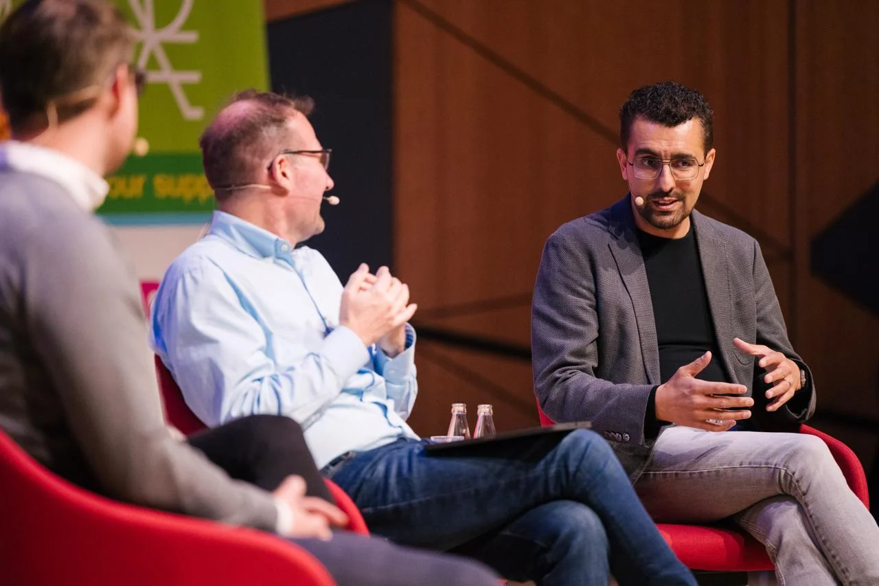Paneldiskussion mit Alexander Hendorf und weiteren Expertinnen und Experten auf einer Konferenzbühne